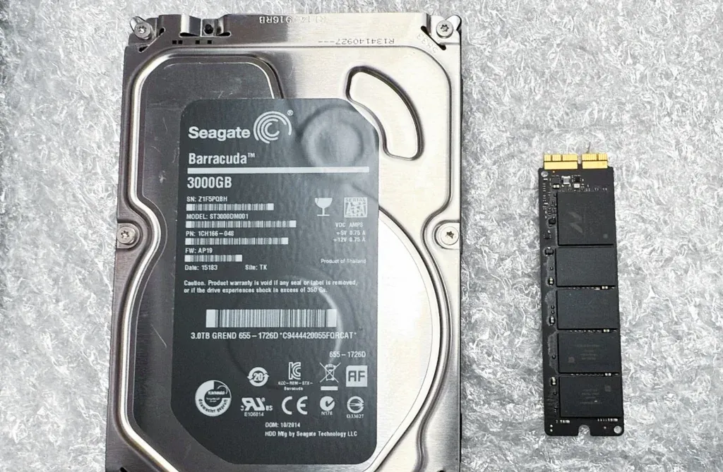 Un disco duro de 3 TB junto a un SSD de Mac, para comparar el tamaño