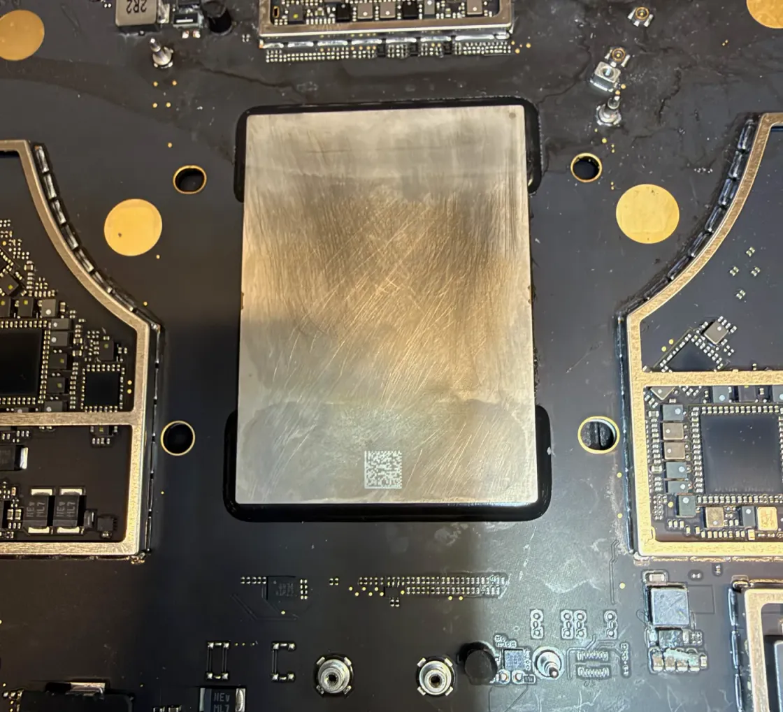 Placa base de un MacBook abierta con el blindaje retirado, con la zona del almacenamiento y sus conectores a la vista